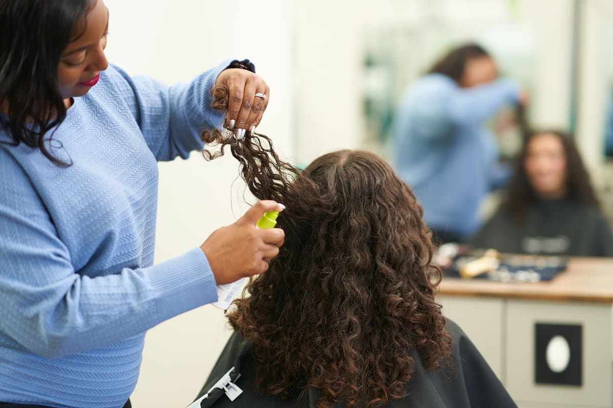 Great Clips stylist applying product to the back of a female's hair Great Clips stylist applying product to the back of a female's hair