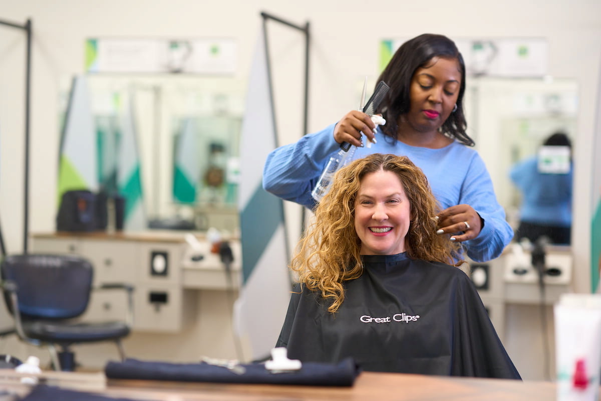 woman with curly hair getting a haircut in a Great Clips salon woman with curly hair getting a haircut in a Great Clips salon