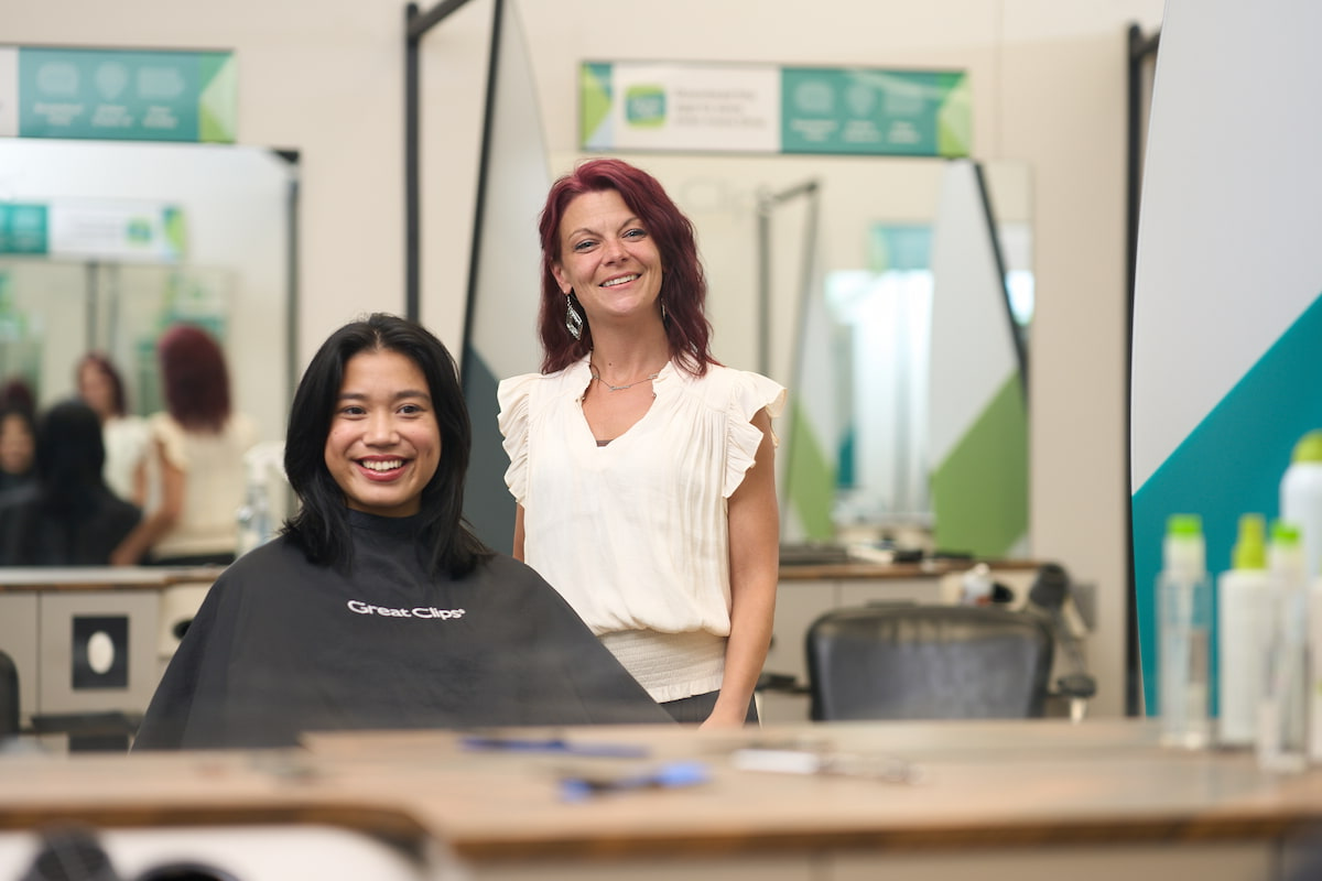 A woman smiling in a Great Clips salon chair next to her stylist A woman smiling in a Great Clips salon chair next to her stylist
