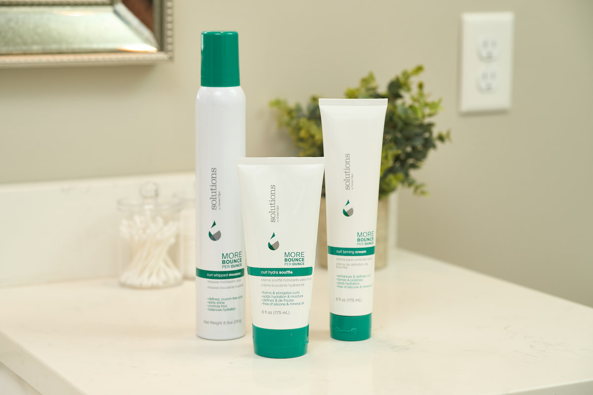 Solutions by Great Clips curl products on bathroom counter Solutions by Great Clips curl products on bathroom counter